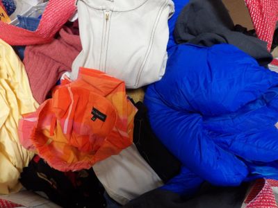 a pile of clothes sitting on top of a bed