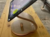 a tablet computer on a wooden stand on a table