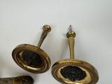 three antique brass door knobs and handles on a white surface