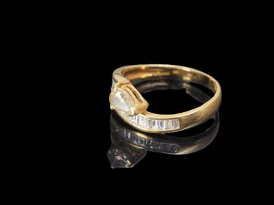 gros plan d'une bague en or avec des diamants sur une surface noire