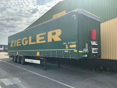 un grand camion vert garé devant un immeuble