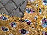 a close up of a yellow dress with red flowers on it