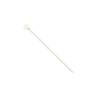 un bâtonnet blanc orné d'une perle, posé sur une surface blanche