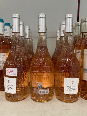 plusieurs bouteilles de vin sont alignées sur une étagère