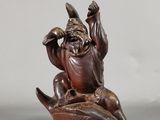 une image représentant la statue d'un homme assis sur une banane