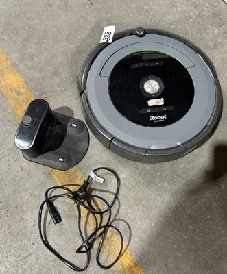 un robot posé par terre à côté d'un chargeur
