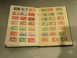 un livre ouvert avec des timbres, posé sur une table