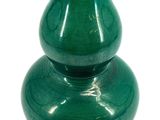 a green vase that is sitting on a white surface