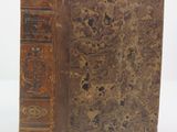 an old book sitting on top of a table next to a white background
