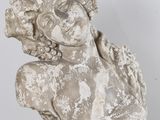 statue d'une femme à la tête fleurie, posée sur un socle noir