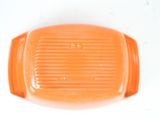 an orange plastic object on a white surface