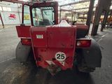 a red tractor that is parked inside of a building