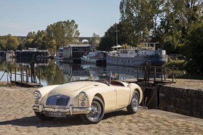 une voiture blanche garée sur le sable près d'un plan d'eau