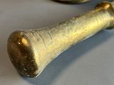 a gold mortar and a brass pepper shaker on a white table