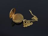 a gold locke with a chain around it on a black surface