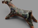 sculpture of a horse made of clay on a gray surface