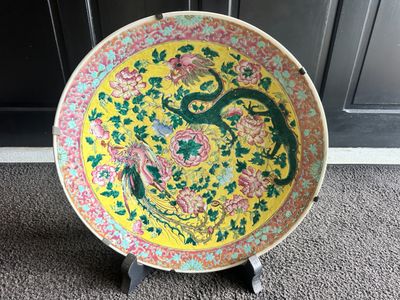 a yellow plate with a dragon on it sitting on a stand
