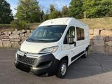 the white van is parked in a parking lot near a stone wall