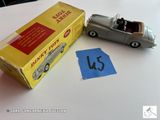 une petite voiture posée à côté d'une boîte sur laquelle est collé un autocollant