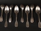 six spoons are arranged in a row on a black surface
