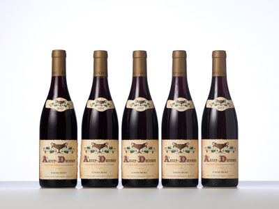quatre bouteilles de vin sont alignées sur une table