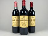 trois bouteilles de vin rouge posées côte à côte sur une table
