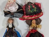 four dolls of different colors and sizes are lined up on a white surface