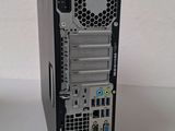 a small computer on a white table next to a keyboard