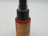 a close up of a bottle of liquid on a white surface