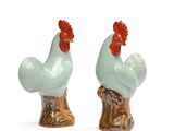 deux figurines de coq en céramique posées sur une souche d'arbre