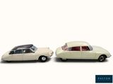 two toy cars sitting next to each other on a white surface