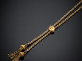 un collier en or orné d'un pompon sur fond noir