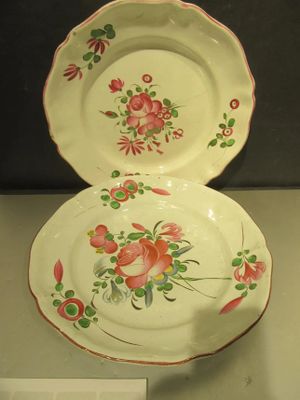 deux assiettes ornées de fleurs, exposées dans une vitrine