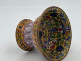 a vase with a colorful design on it on a white surface