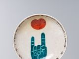 une petite assiette sur laquelle sont peints une main et un cœur