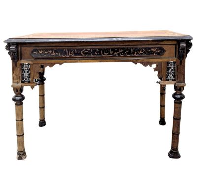 une photo d'une table en bois dont le plateau est orné de sculptures