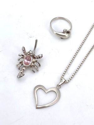 silver necklace, ring, and pendant with a heart and a spider