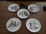 four plates with different designs on them sitting on a wooden table