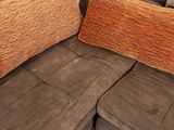 two pillows that are sitting on a brown couch