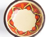 a small bowl with a red and yellow design on it