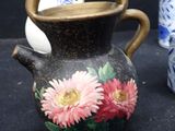 three vases with flowers painted on them on a table