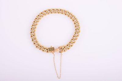 a gold chain bracelet with a heart charm on a white background