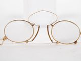 pair of glasses with gold rims on a white background