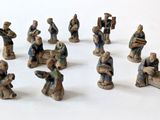 many figurines of people sitting on a white surface