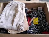 a cardboard box filled with clothing and a wooden hanger