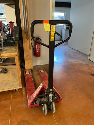 un chariot rouge muni d'une poignée noire dans une pièce