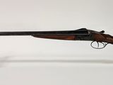 un fusil avec un canon en bois sur un support transparent