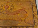 an old wooden box with a painting of a bird and a chalicet