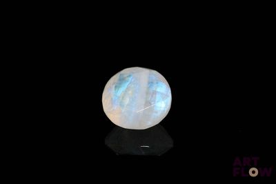une image représentant une pierre de lune blanche posée sur une surface noire