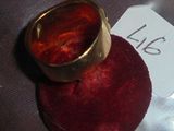 une bague en or posée sur un coussin en velours rouge